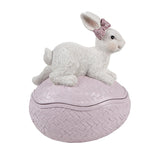 Gesloten roze decoratie ei met wit haasje en roze strik als sfeervolle paasdecoratie