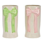 Twee witte keramische vazen met een grote strik in reliëf, één in pastelroze en één in pastelgroen