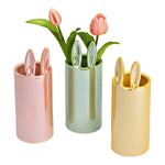 Drie porseleinen konijnenvazen in roze, groen en geel met tulpen; vrolijke paasdecoratie van 23 cm hoog, per stuk verkrijgbaar.