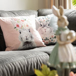 Combinatie van de roze en groene kussenhoezen met konijnenopdruk op een bank, decoratieve voorjaarskussens per stuk verkrijgbaar.