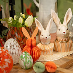 Sfeervolle paastafel styling met een peach honingraat haas gecombineerd met witte paasfiguren en moderne lente decoratie.