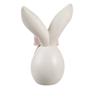 Achterkant van een glad wit decoratie ei met lange konijnenoren voor een moderne paastafel