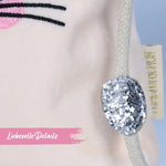 Detail van de witte koordsluiting met een glinsterend zilveren detail op het roze velvet tasje