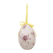 Detailopname van een vintage paasei hanger met een boeket van roze bloemen en een zonnig geel lintje