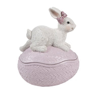 Gesloten roze decoratie ei met wit haasje en roze strik als sfeervolle paasdecoratie