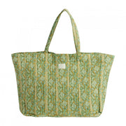 Vrijstaande productfoto van een grote olijfgroene quilted shopper met een verticaal gestreept bloemenpatroon en lange hengsels.