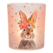 Roze glazen kaarshouder van 10 cm hoog met een illustratie van een paaskonijn met bloemenkrans en kleine hartjes, sfeervolle paasdecoratie.