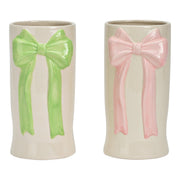 Twee witte keramische vazen met een grote strik in reliëf, één in pastelroze en één in pastelgroen