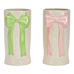 Twee witte keramische vazen met een grote strik in reliëf, één in pastelroze en één in pastelgroen