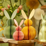 Gele en groene honingraat paashazen op een houten tafel, sfeervolle duurzame paasdecoratie en tafelstyling