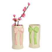 Productfoto van de witte keramische vaas met roze strik, gevuld met een kunstmatige roze bloesemtak